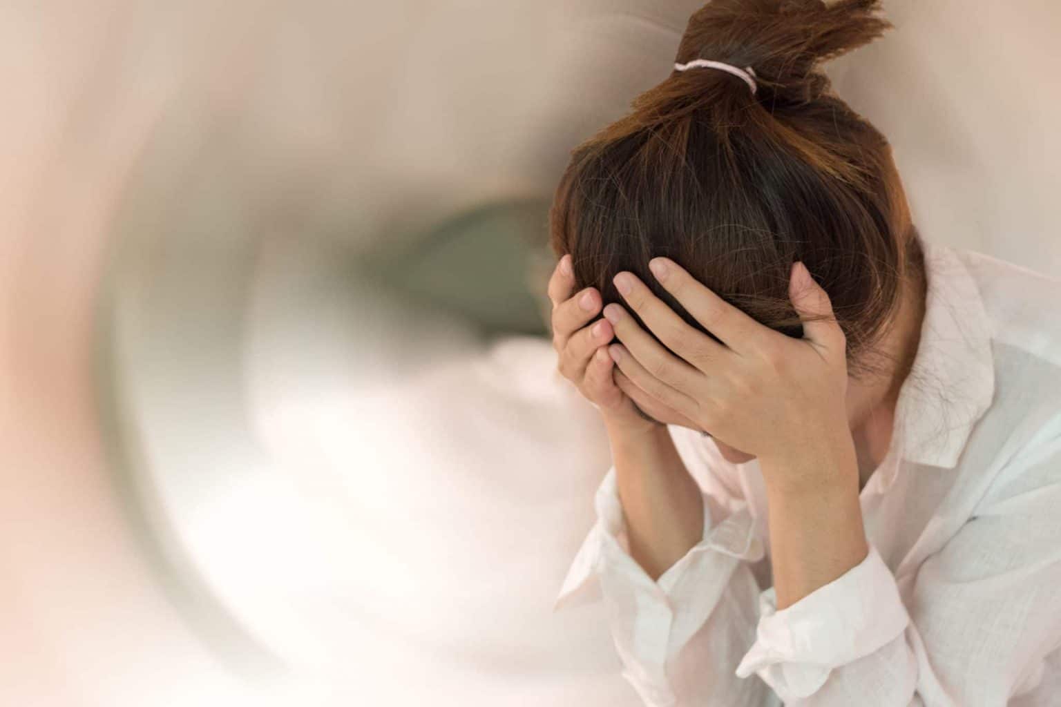 woman holding head suffering from dizziness or vertigo woman holding head with spinning graphic displaying a sense of disorientation